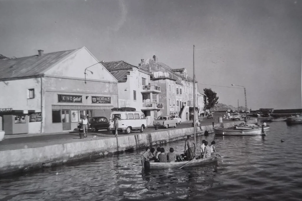 Pogled na kino Galeb i dućan prehrane na rivi u Karlobagu