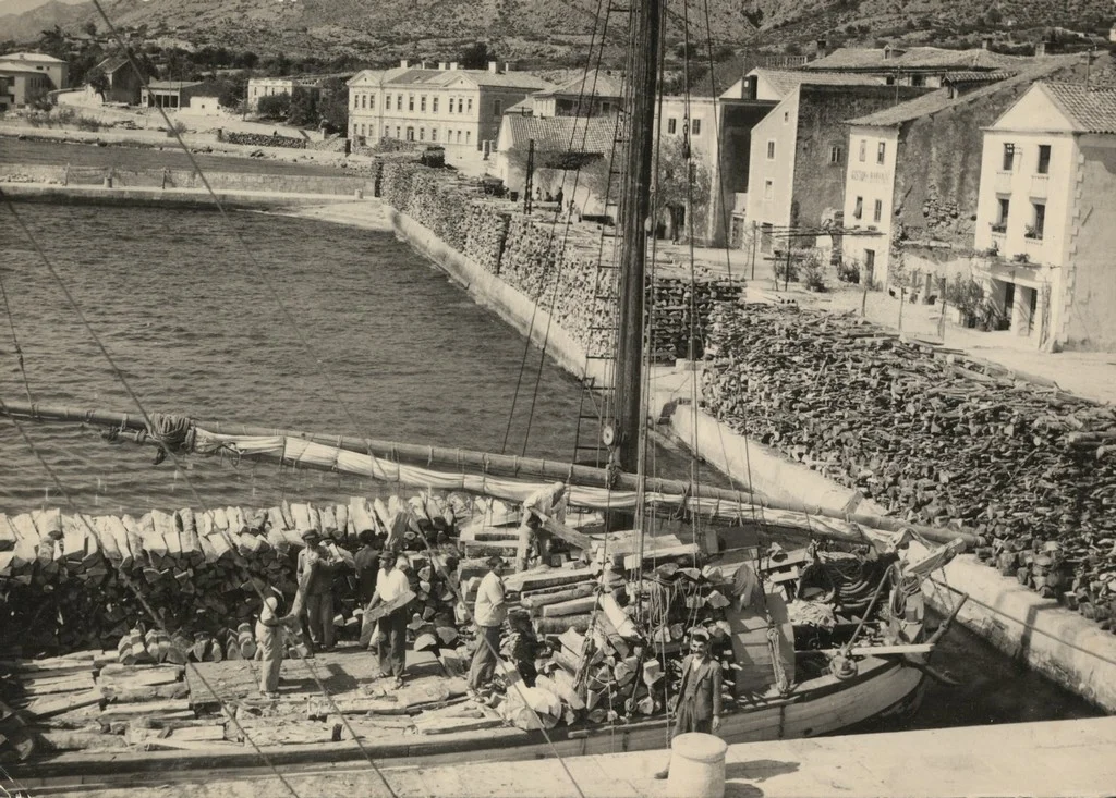 Pogled na lučku aktivnost i velike zalihe drva u luci Karlobag